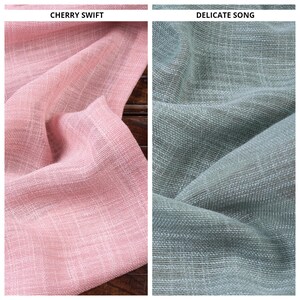 May include: Two fabric swatches, one in a light pink color called "Cherry Swift" and the other in a light green color called "Delicate Song".