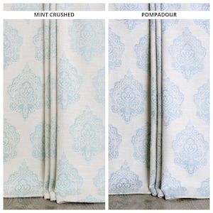 Pode incluir: Duas amostras de tecido com fundo branco e um padrão damasco azul e branco. As amostras são etiquetadas como "Mint Crushed" e "Pompadour".