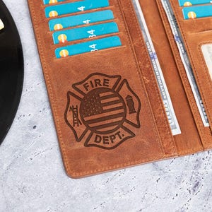May include: A brown leather wallet with a fire department emblem featuring an American flag and the words "FIRE DEPT."