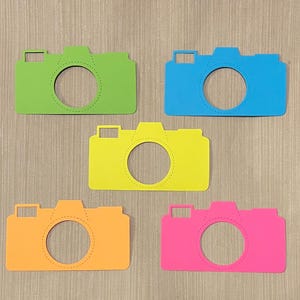 May include: Five colorful paper camera cutouts. The cameras are in shades of green, blue, yellow, orange, and pink.