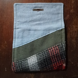 May include: A blue, green, and red patchwork fabric pouch with a button closure.