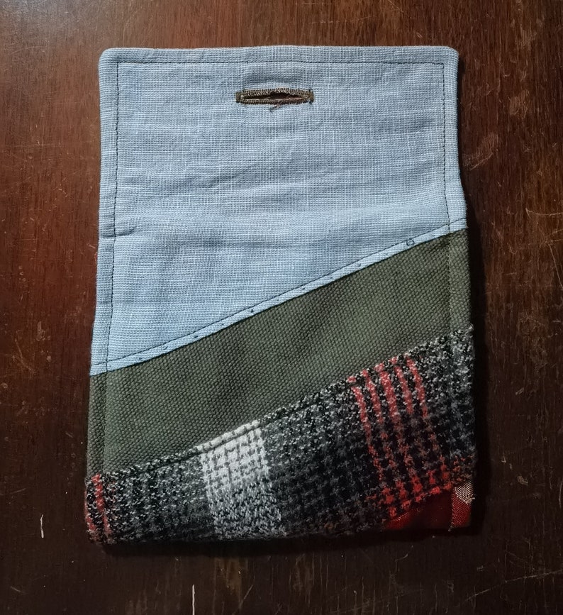 May include: A blue, green, and red patchwork fabric pouch with a button closure.