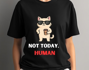 May include: Black t-shirt featuring a cartoon cat wearing sunglasses and holding a coffee cup. The text "NOT TODAY, HUMAN" is printed below the cat in white and red. The shirt is a crew neck.