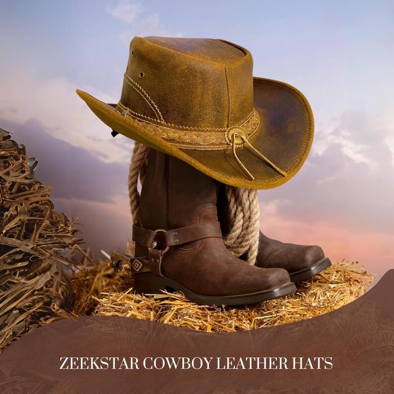 May include: A brown leather cowboy hat with a braided band and a rope accent sits on top of a pair of brown leather cowboy boots. The boots have a buckle strap and a spur. The hat and boots are sitting on a pile of hay.