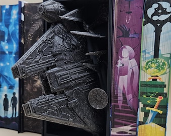May include: A black 3D printed spaceship model is displayed in a bookend. The spaceship is partially sticking out of the bookend. The bookend is made of wood and has a black frame. The spaceship is detailed and has a textured surface.