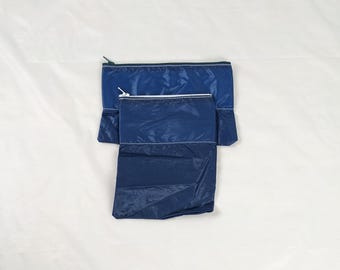 Twee marineblauwe, zijdeachtige zakjes met schuifritssluiting