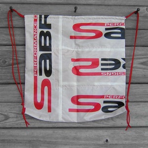May include: White drawstring bag with red and black text that reads "SABF Performance Designs" and "SABF Performance".