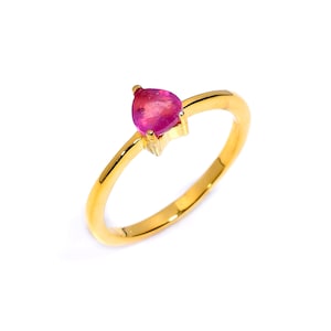 Op de afbeelding: Een gouden ring met een enkele, peervormige, felroze edelsteen in een eenvoudige zetting met pootjes. De ringband is van glad, gepolijst geelgoud en heeft een strak ontwerp dat de centrale roze steen aan de bovenzijde goed laat uitkomen.