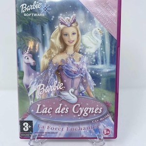 Op de afbeelding: Een Barbie "Lac des Cygnes" CD-ROM-hoes. De cover toont een Barbie-pop in een roze en blauwe jurk, met een zwaan en een eenhoorn. De hoes heeft het Barbie Software-logo en de tekst "La Forêt Enchantée".