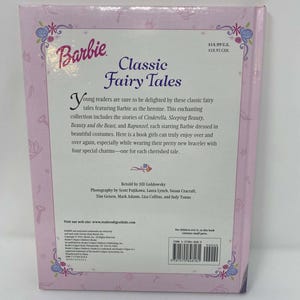 May include: A pink Barbie book titled "Classic Fairy Tales." The cover features the Barbie logo and floral designs. The book includes stories of Cinderella, Sleeping Beauty, Beauty and the Beast, and Rapunzel.