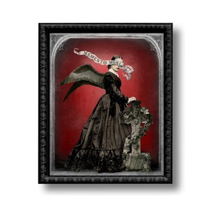 May include: Framed artwork featuring a woman in a black dress with angel wings, standing beside a stone cross. A banner with the words "Memento Mori" is across her eyes. The background is a deep red.