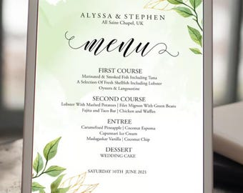 May include: A wedding menu with a watercolor background featuring green leaves and gold accents. The menu lists the courses for the wedding reception, including the first course, second course, entree, dessert, and wedding cake. The date of the wedding is Saturday, June 10th, 2021.