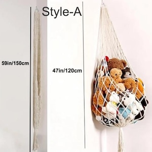May include: A macrame hanging toy storage net, Style-A, in cream color. The net is 47 inches (120 cm) wide and 59 inches (150 cm) long. The net is filled with various stuffed animals, including teddy bears and other plush toys.