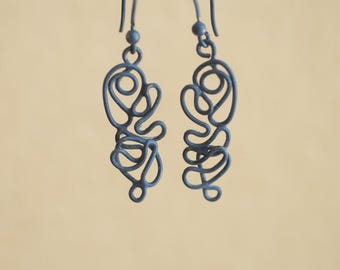 May include: A pair of dark blue, abstract wire earrings. Each earring features a looping, swirling design suspended from a small hook. The earrings have a matte finish and are displayed against a neutral background.