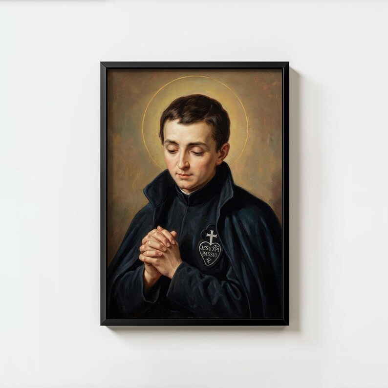 May include: Framed portrait of a man with dark hair, wearing a black cloak and a white emblem with a cross and text. The man is depicted with his hands clasped in prayer, and a golden halo surrounds his head. The artwork is set against a neutral background.