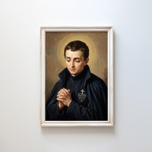 May include: A framed portrait of a man with a halo, dressed in a black cloak and jacket, with clasped hands. The portrait has a warm color palette with a gold halo and a white frame. The image features a religious theme.