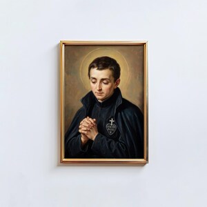 May include: A framed portrait of a man with a halo, dressed in a dark cloak and black garment, with hands clasped in prayer. The gold frame surrounds the image, set against a white background.