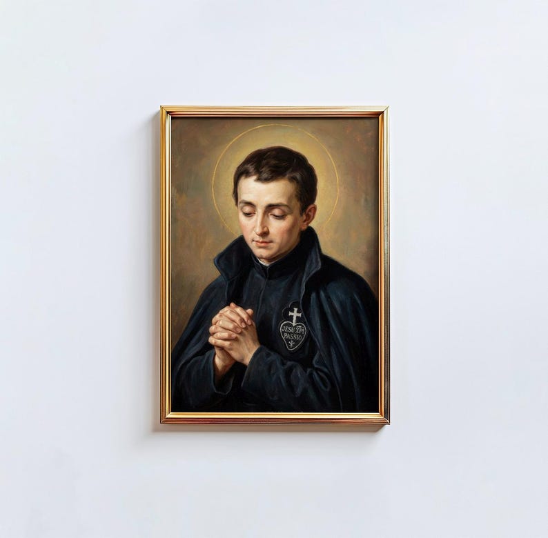 May include: A framed portrait of a man with a halo, dressed in a dark cloak and black garment, with hands clasped in prayer. The gold frame surrounds the image, set against a white background.