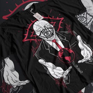 Peut inclure: T-shirt noir avec un motif représentant un homme en costume avec un grand œil sur le visage. L'homme tient un globe terrestre dans ses mains. Le motif est entouré de lignes rouges et d'un œil rouge.