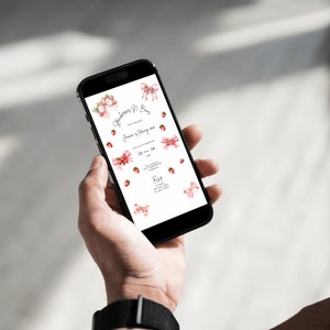 May include: A smartphone displaying a digital invitation with a pink and white floral design. The invitation reads "Strawberry & Bow Tie" and includes the date "23 or 24" and the word "RSVP".