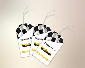 May include: Three white favour tags with black and white chequered flags at the top. Each tag has a yellow racing car and the text "Thanks for Racing by!"