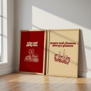 Framed retro kitchen print with bold red typography 'meats and cheeses always pleases' and a charcuterie basket illustration.
