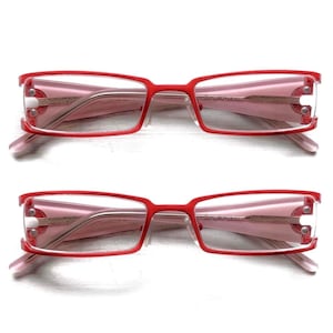 以下が含まれることがあります： 長方形フレームのメガネが2組。 フレームは赤色で、レンズとテンプルはピンク色です。 デザインは側面にシルバーのアクセントが付いています。 メガネは白い背景に配置されています。