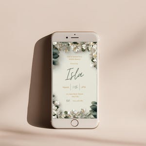 Editable bridal shower invitation displayed on mobile phone screen, white floral Canva template design