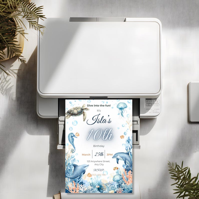 May include: A white printer printing a birthday invitation. The invitation features an underwater theme with a turtle, seahorse, dolphin, and jellyfish. Text on the invitation reads "Dive into the fun! It's Isla's 10th Birthday March 25th 3PM."