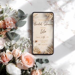 Boho pampas bridal shower invitation template displayed on a mobile phone, minimalist neutral beige design, editable in Canva, instant download