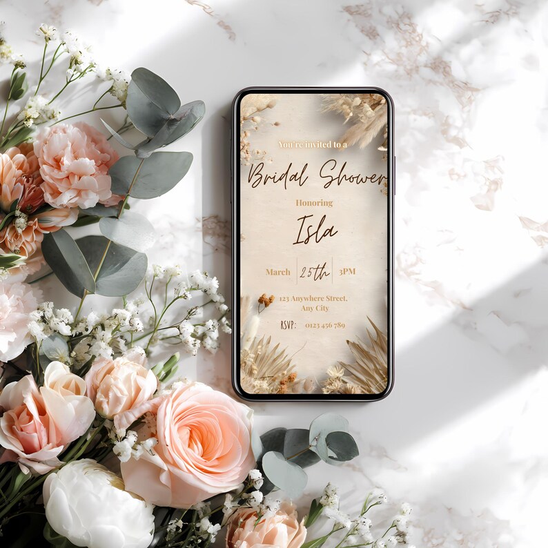 Boho pampas bridal shower invitation template displayed on a mobile phone, minimalist neutral beige design, editable in Canva, instant download