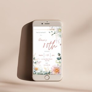 80th birthday invitation template displayed on mobile phone screen, editable Canva floral invitation for garden party celebration