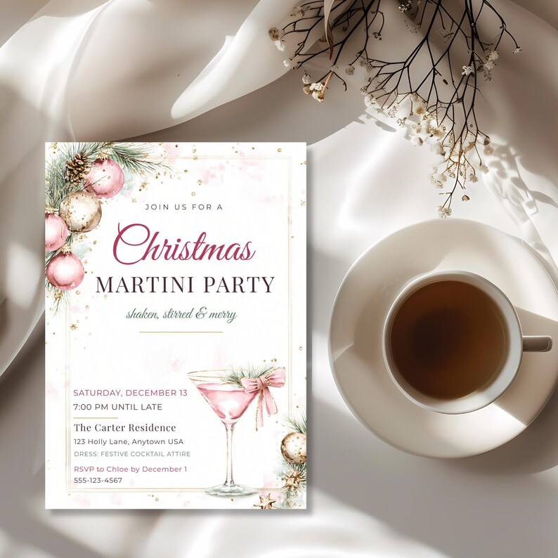 Elegant pink Christmas cocktail party invitation beside a cup of tea on draped white satin.