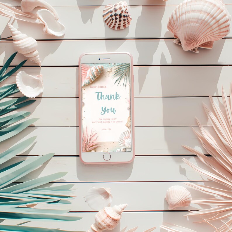 Puede incluir: Un tel&eacute;fono inteligente rosa muestra una tarjeta de "Gracias" con un tema de playa, rodeada de conchas marinas y hojas de palma sobre una superficie de madera blanca. La tarjeta presenta texto e ilustraciones de conchas y plantas.
