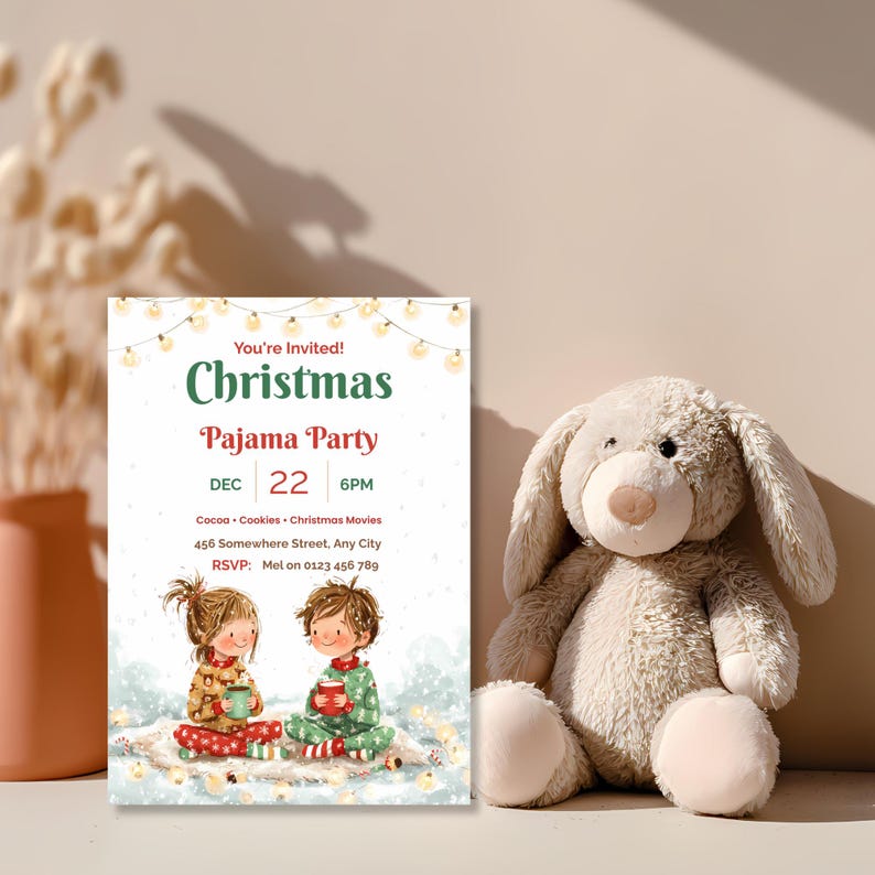 Watercolor Christmas pajama party invitation propped beside a plush bunny and dried flowers in soft natural light