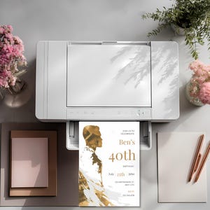 Printed mens birthday invitation coming out of a printer with gold artistic male silhouette and clean modern typography
