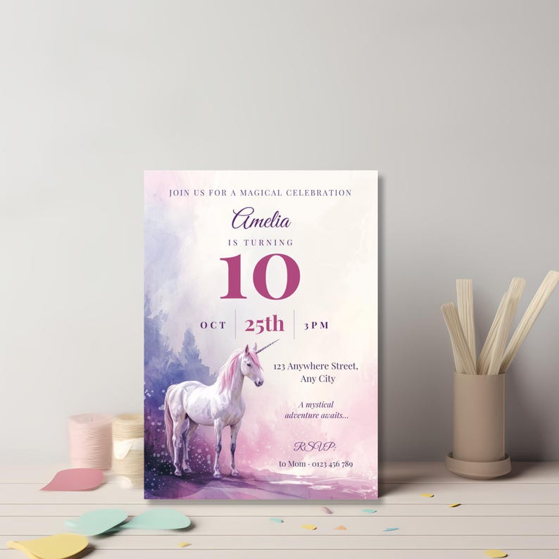 Elegant purple unicorn birthday invitation for girls leaning against a gray wall on a pastel desk