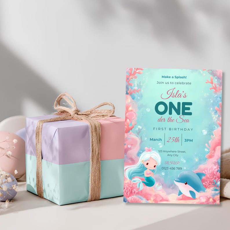 Oneder the Sea mermaid first birthday invitation next to a pastel pink, lilac and mint gift box.