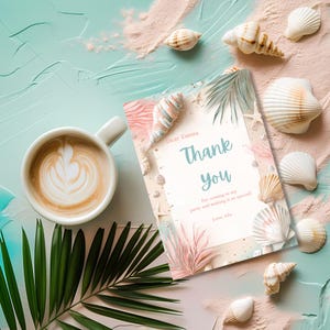 Puede incluir: Una tarjeta de agradecimiento con las palabras "Thank You" en azul claro, rodeada de conchas marinas y hojas tropicales. Tambi&eacute;n hay una taza de caf&eacute; con arte latte y una hoja de palma. La tarjeta dice "Dear Emma, For coming to my party and making it so special! Love, Ida."