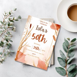 Editable boho 50th birthday invitation displayed on a table beside a cup of coffee and eucalyptus leaves