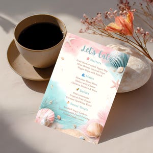 May include: A menu with a beach theme, featuring the text "Let's Eat." The menu lists starters, mains, drinks, and sweet treats. The design includes seashells, starfish, and a watercolor background in shades of blue, pink, and sand.