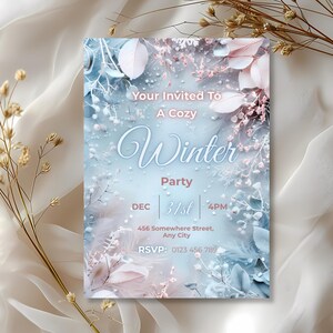 May include: A winter party invitation with a soft, dreamy aesthetic. The design features a gradient of blue and white with delicate floral and feather accents. Text includes "Your Invited To A Cozy Winter Party" and event details.