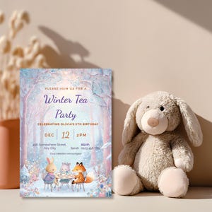 Girl winter tea party birthday invitation leaning beside a soft plush bunny, editable woodland animal tea party invite with fox, bunny and kitten in a pastel snowy forest