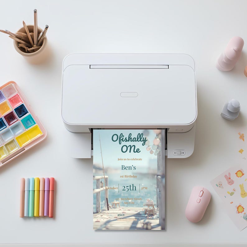 Printed 5x7 inch “Ofishally One” first birthday invitation shown on paper featuring fishing theme, coastal dock background, and editable party details.