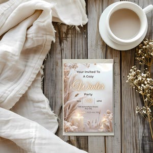 Candlelit neutral boho winter invitation flat lay styled with coffee and gold dried florals