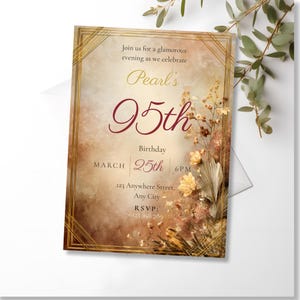 Art Deco amber 95th birthday invitation template shown as a printed card with a white envelope, surrounded by green eucalyptus stems on a white background