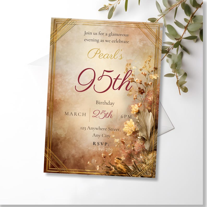 Art Deco amber 95th birthday invitation template shown as a printed card with a white envelope, surrounded by green eucalyptus stems on a white background