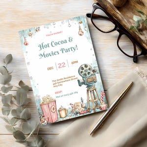 Hot cocoa and movies party invitation on a wood table with eucalyptus and pen