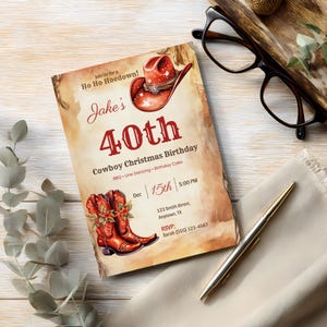 Rustic cowboy Christmas 40th birthday invitation card on a whitewashed wooden desk with eucalyptus, glasses and a gold pen