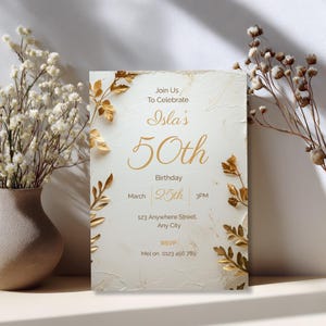 Luxury cream and gold 70th birthday invitation leaning on shelf — elegant floral botanical Canva template for milestone celebration